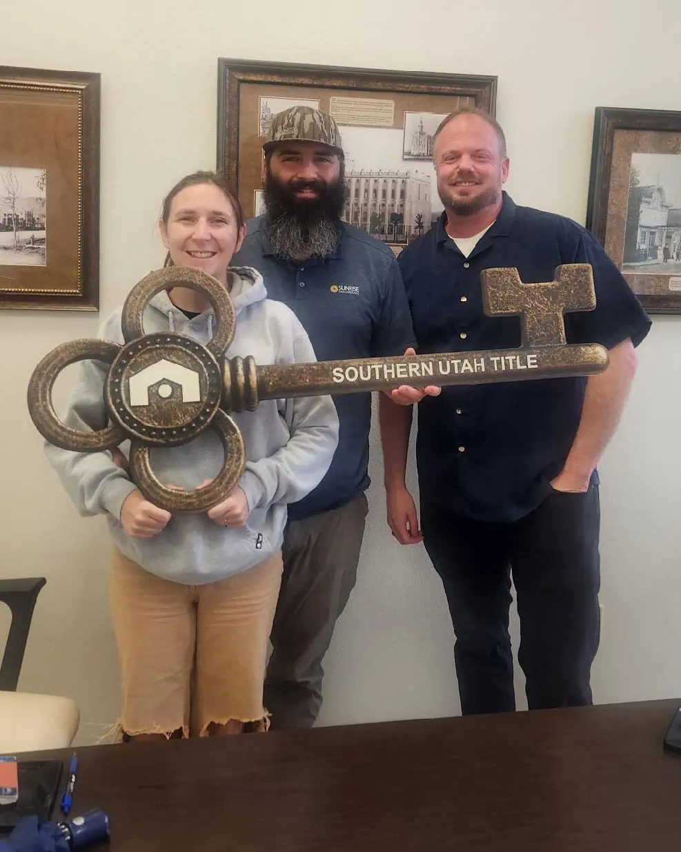 Happy clients holding their new house keys outside their home